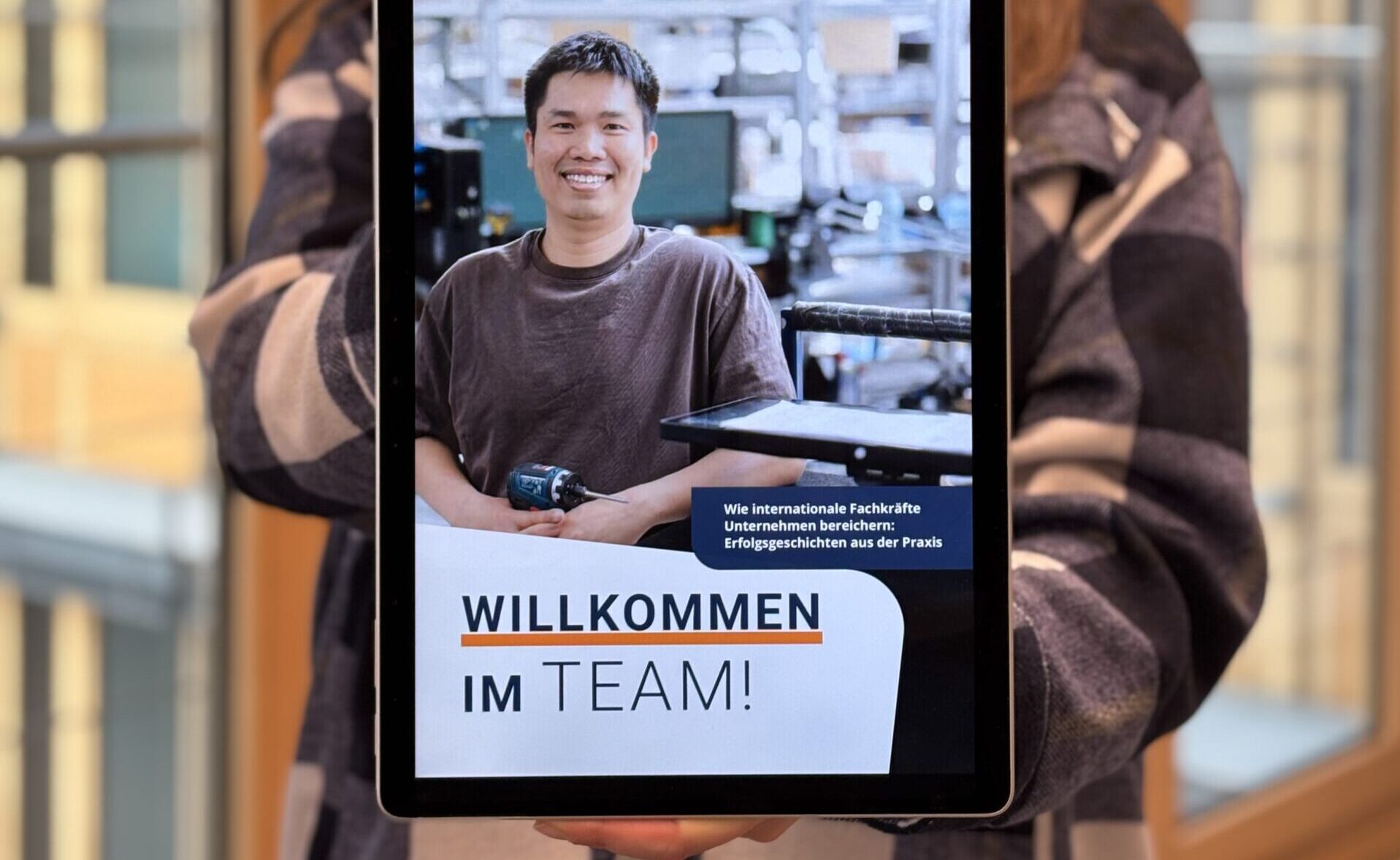 DIHK-Jemand hält ein Tablet in die Kamera, auf dem die erste Seite des Magazins 